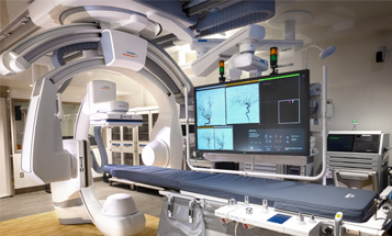 Hospital cath lab with diagnostic imaging system and screen.